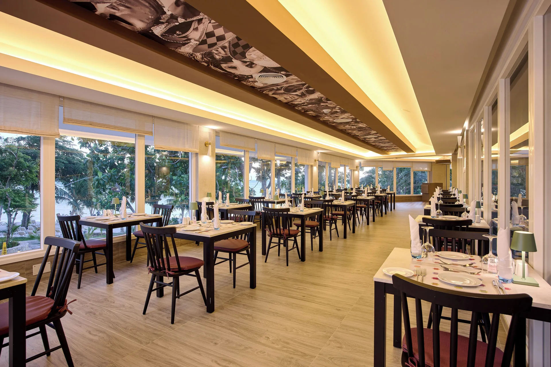 Long dining room with window tables and beach views at Riu Negril.
