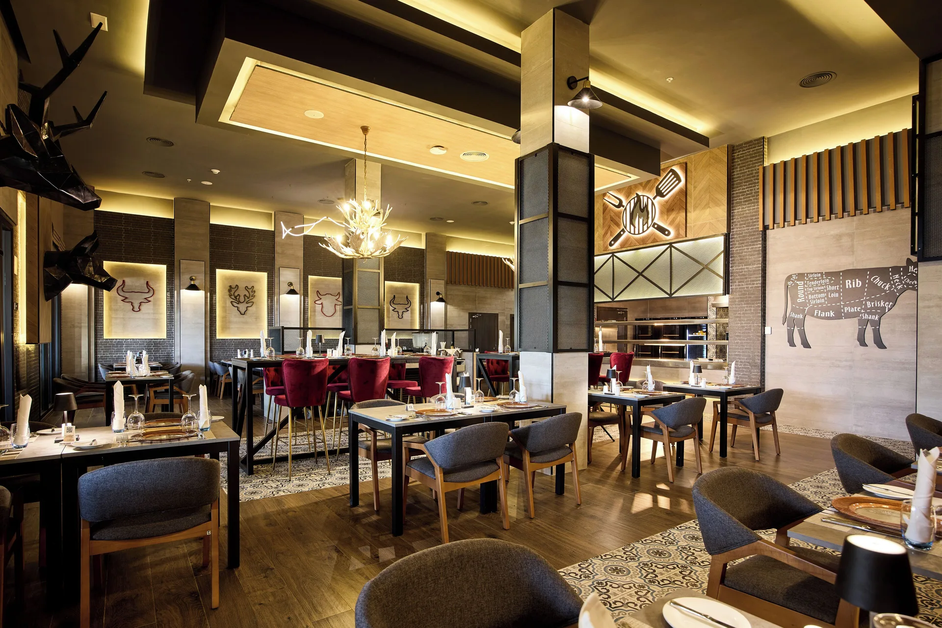 Steakhouse-style dining room with red chairs and meat-cut wall art at Riu Negril.
