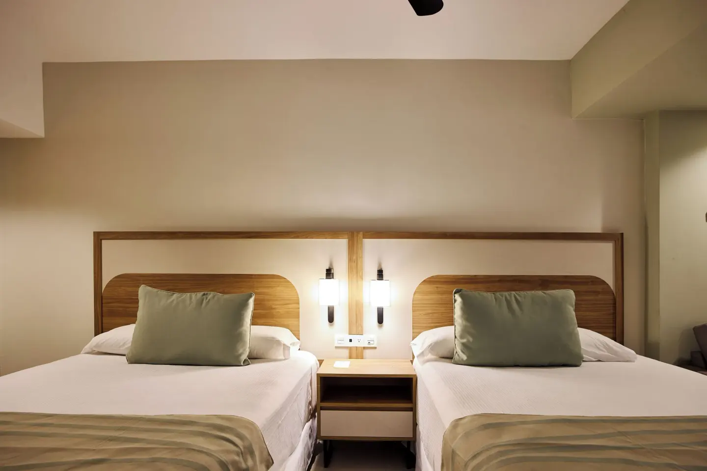 Two beds with wood headboards in a Family Room at Riu Negril.