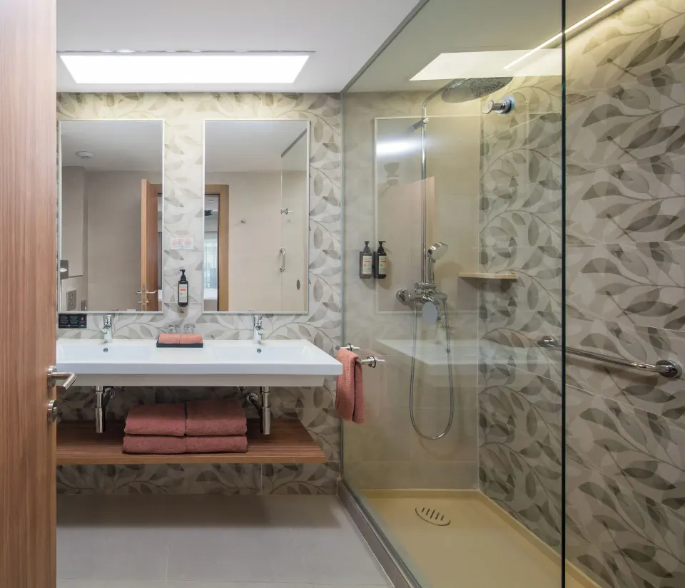 Oceanfront swim-up room bathroom with double vanity and glass shower at Riu Negril.