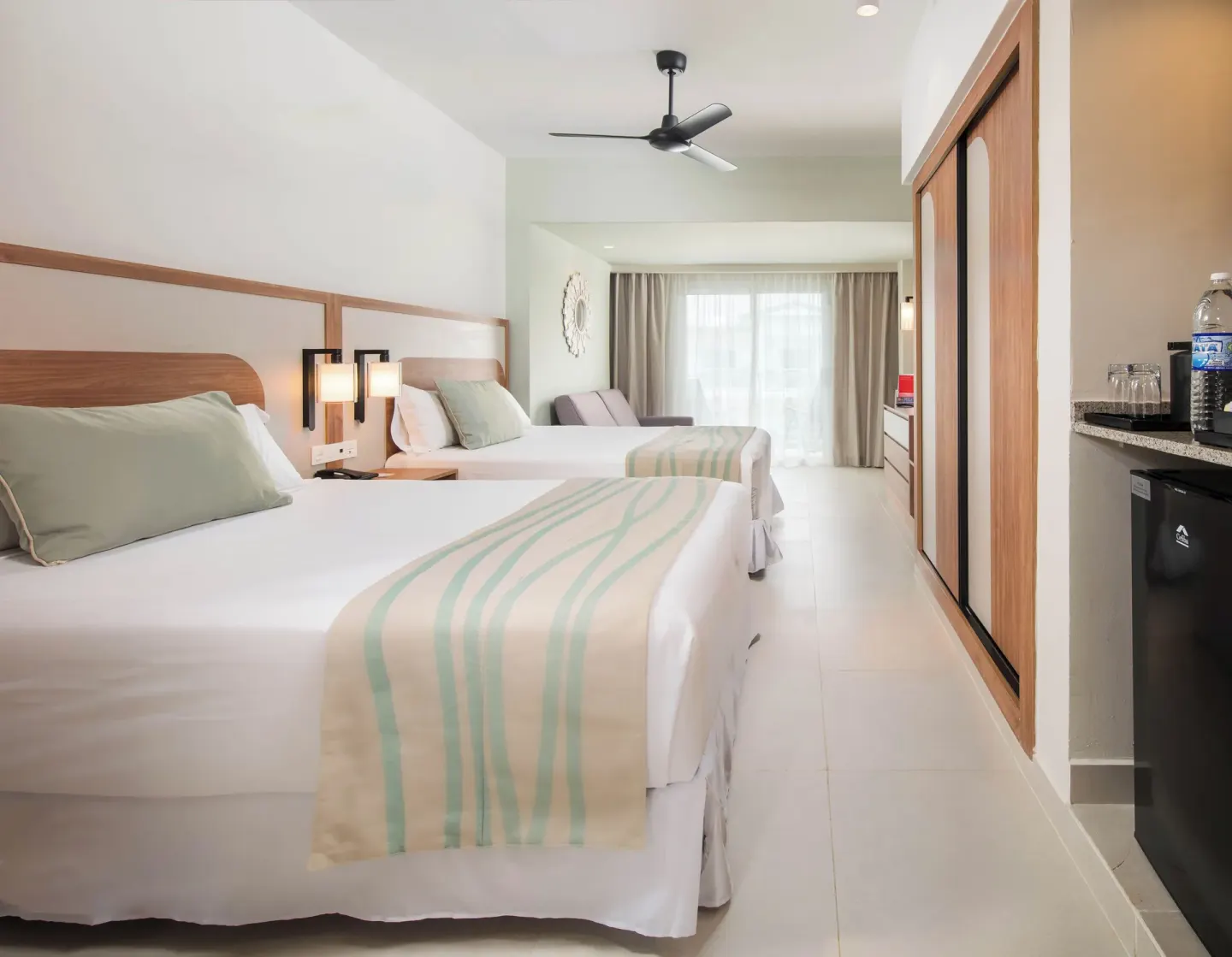 Two-bed guest room with wardrobe and refreshment area at Riu Negril.