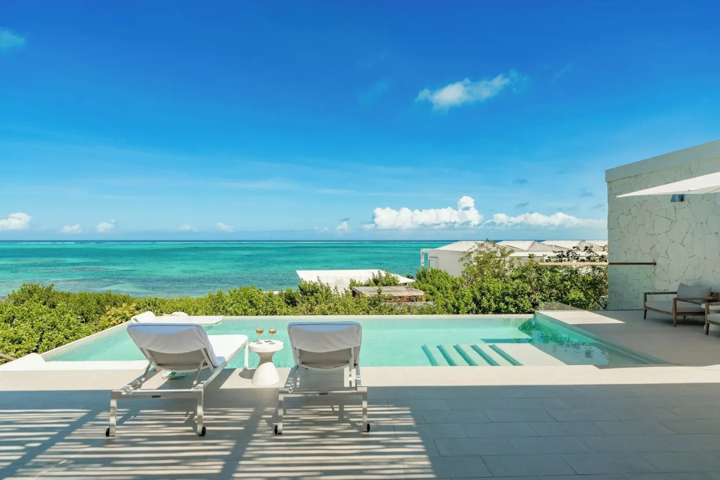 Infinity pool with two loungers facing the turquoise ocean at Rock House.