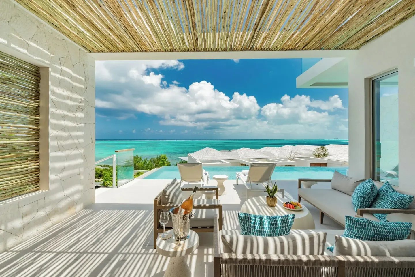 Ocean-facing pool terrace at Rock House with lounge seating, sun chairs, and shaded ceiling.