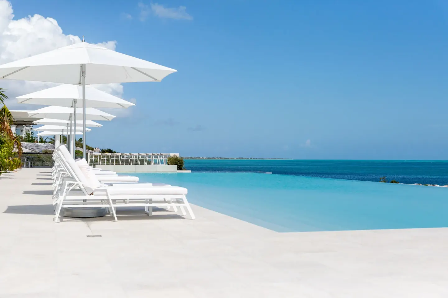 Infinity pool with white loungers and ocean view at Rock House.