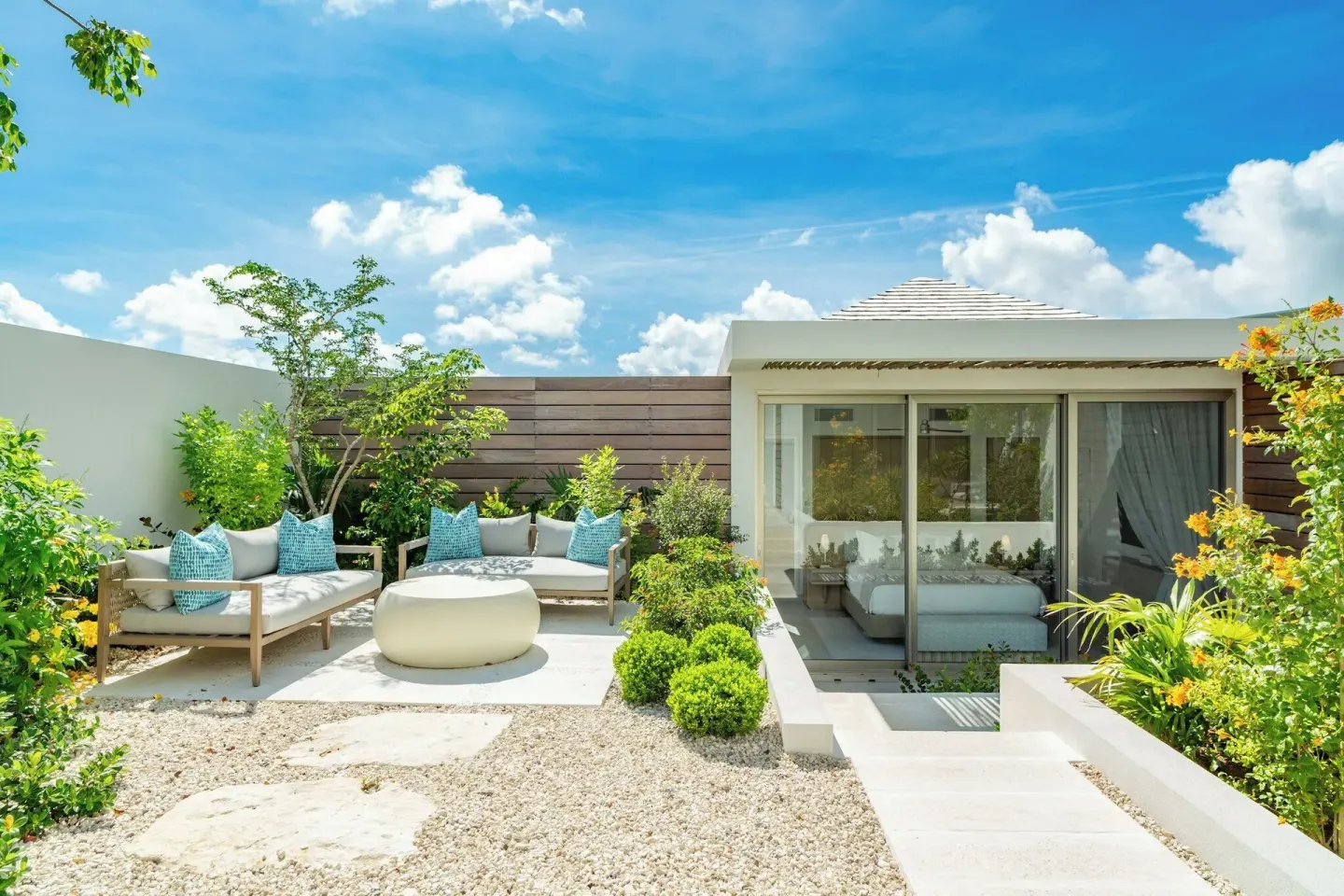 Private garden terrace with outdoor sofas beside a glass-front room at Rock House.