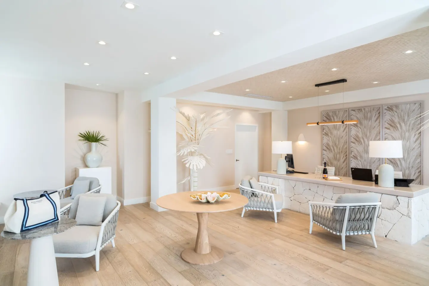 Bright reception lounge at Rock House with seating, a round table, and a front desk.