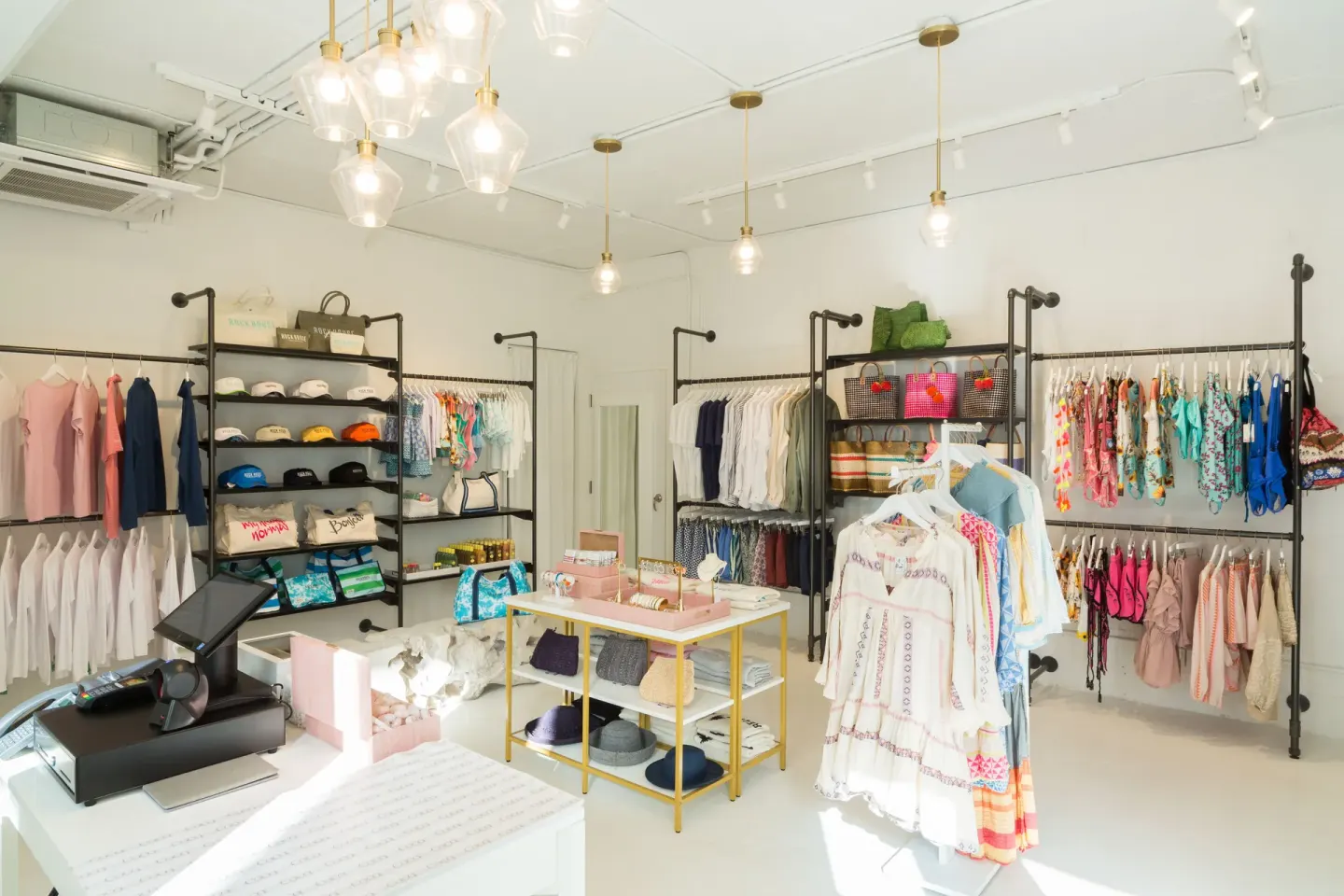 Bright resort boutique with clothing, swimwear, hats, and bags at Rock House.