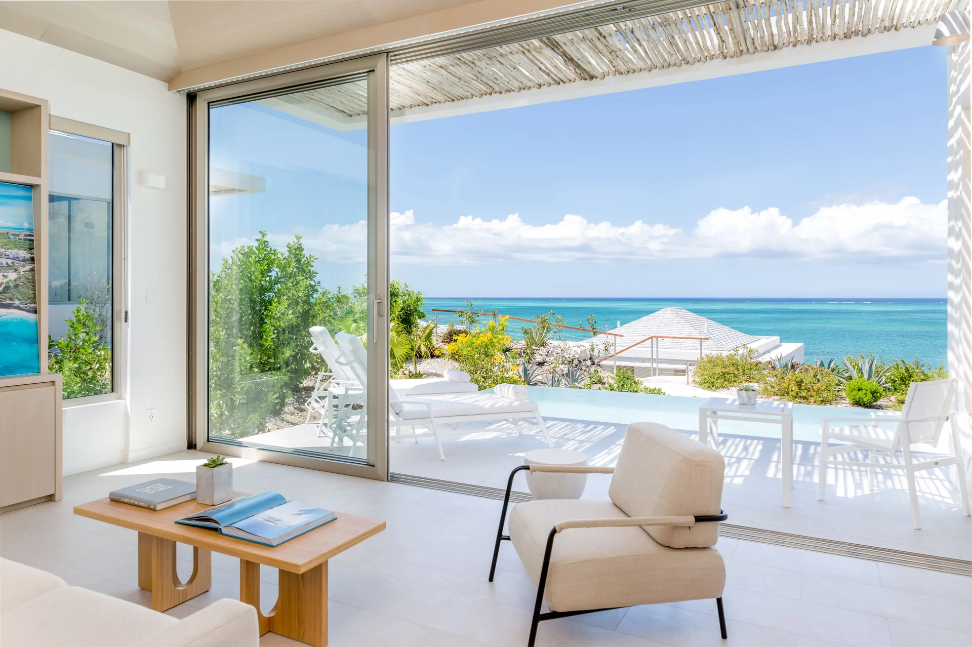 Ocean View Ridge One Bedroom at Rock House with terrace seating and turquoise sea beyond.