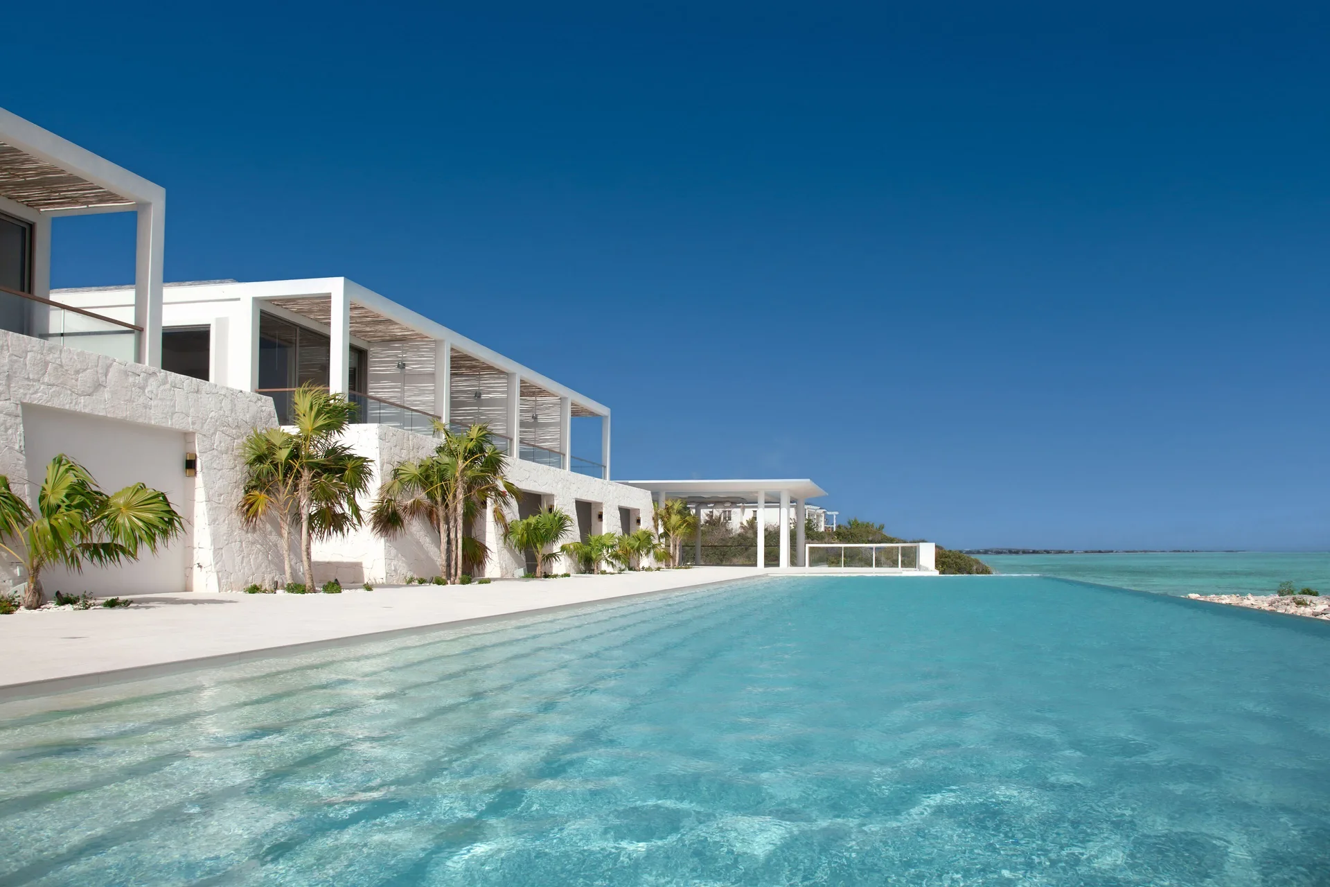 Oceanfront pool beside Oceanfront Pool View Studios at Rock House with turquoise sea beyond.