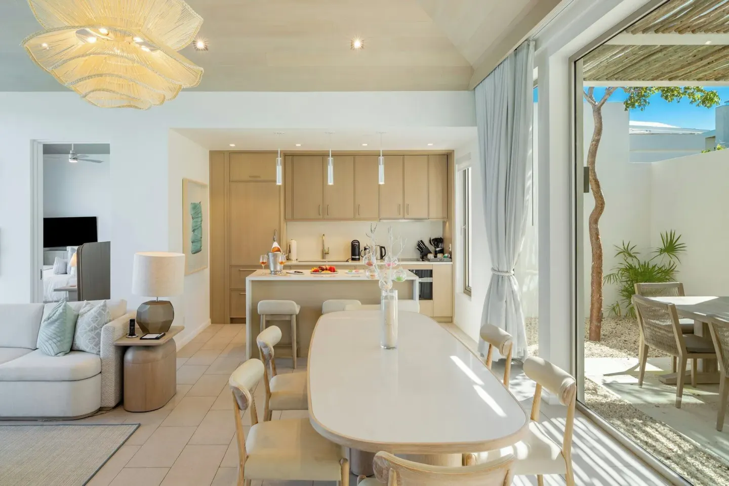 Villa 2-bedroom ocean view dining area and kitchen at Rock House, with patio beyond sliding glass doors.