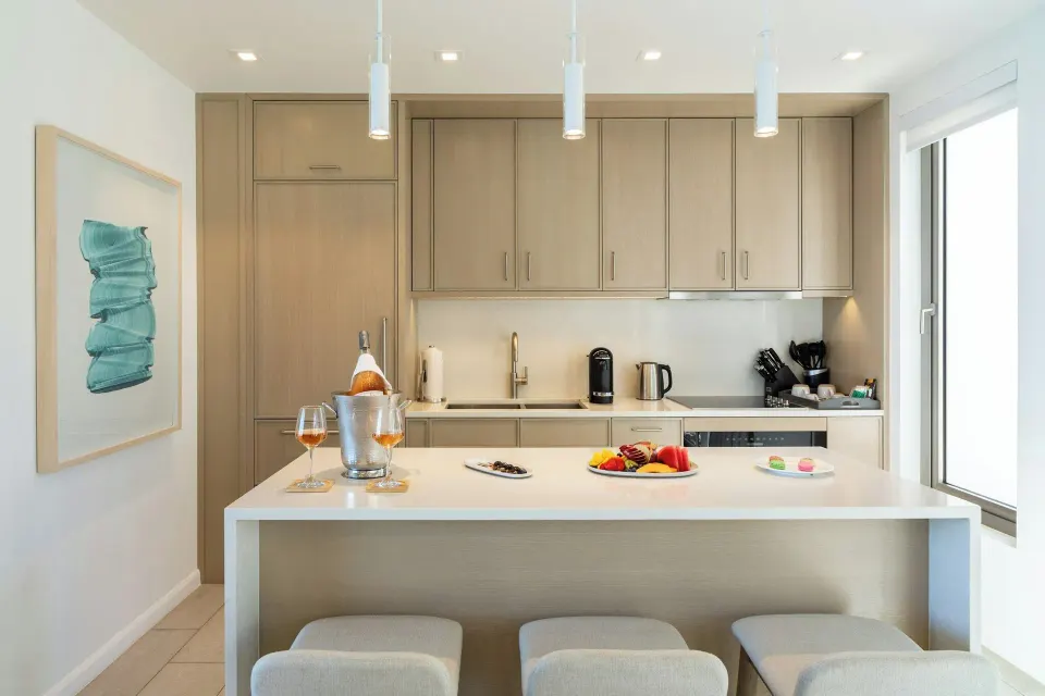 Villa 2-bedroom ocean view kitchen island at Rock House with stools, cabinetry, drinks, and fruit.