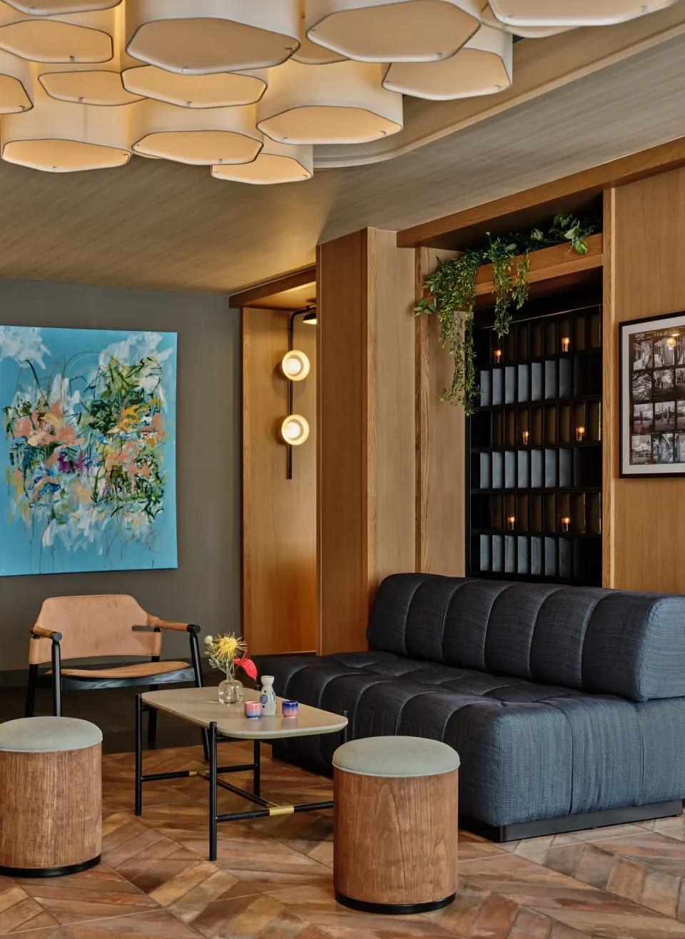 Lounge seating area with sofa, art, and plants at Romer House Waikiki.