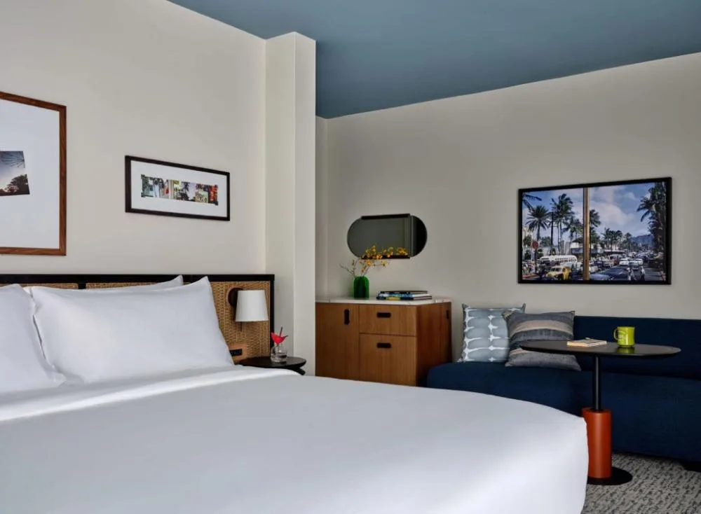 Premium room with king bed and blue sofa at Romer House Waikiki.