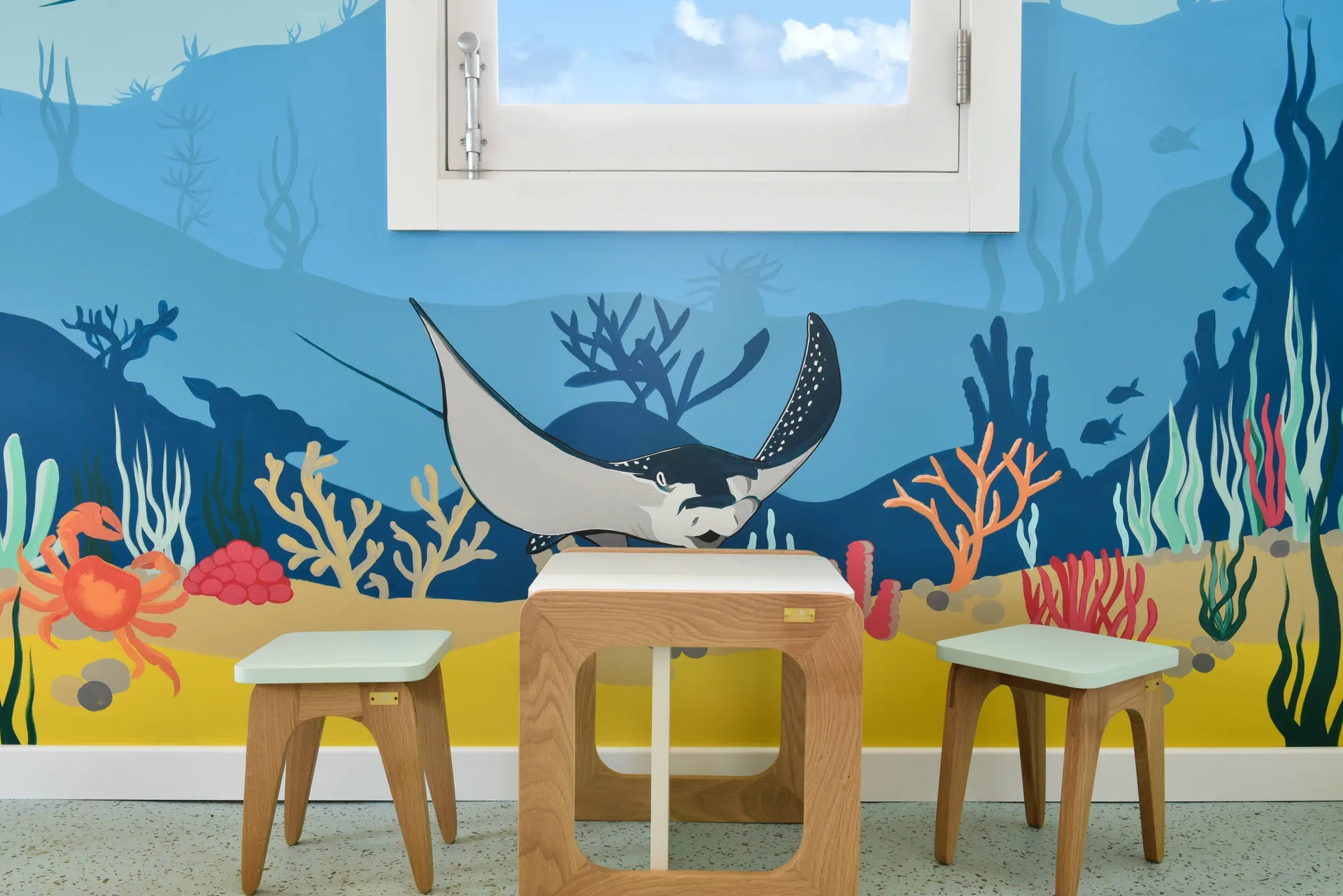 Children's play area with ocean mural and small tables at Rosewood Le Guanahani St Barth.