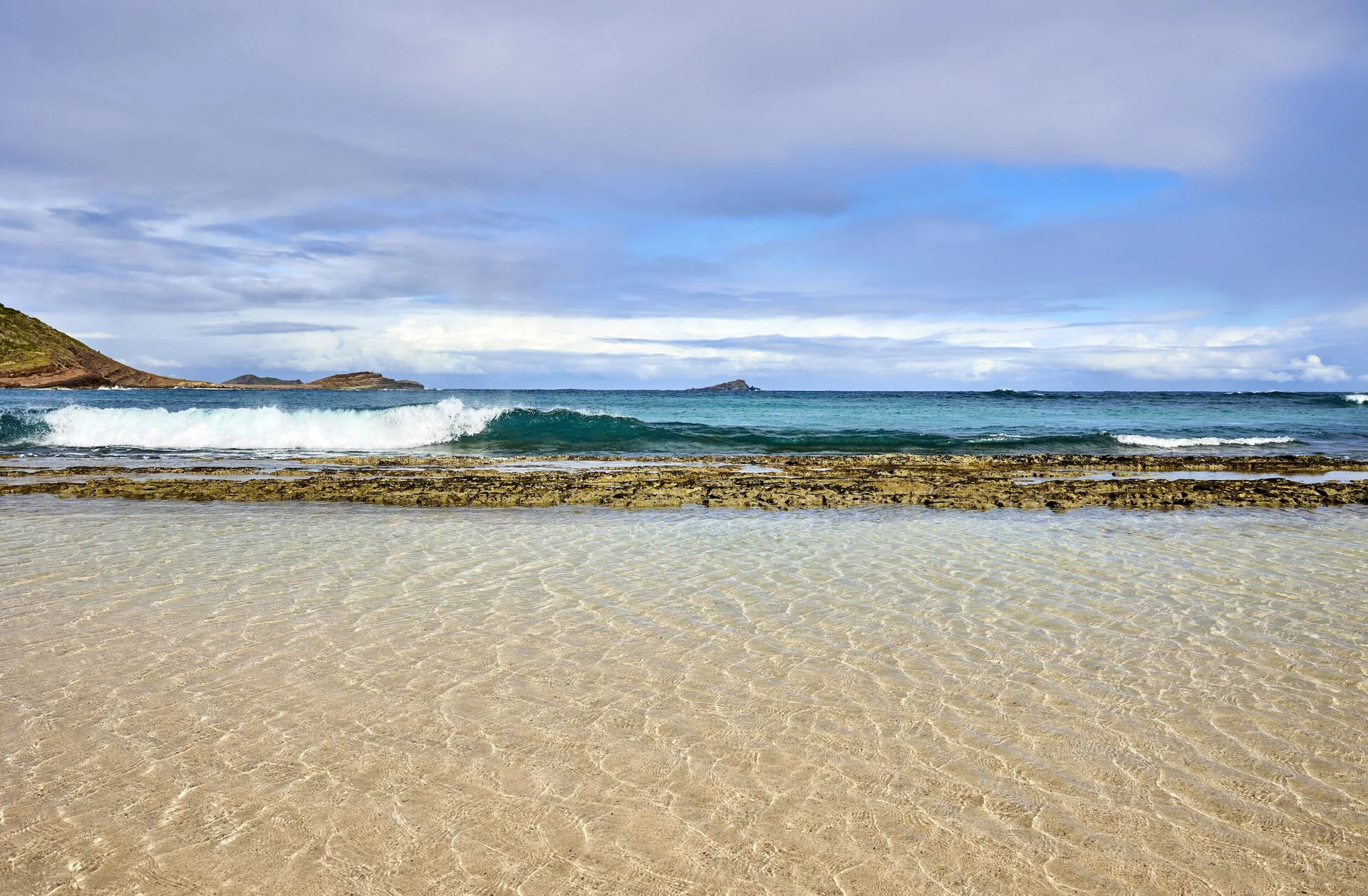 Clear shallow beach water and breaking waves at Rosewood Le Guanahani St Barth.