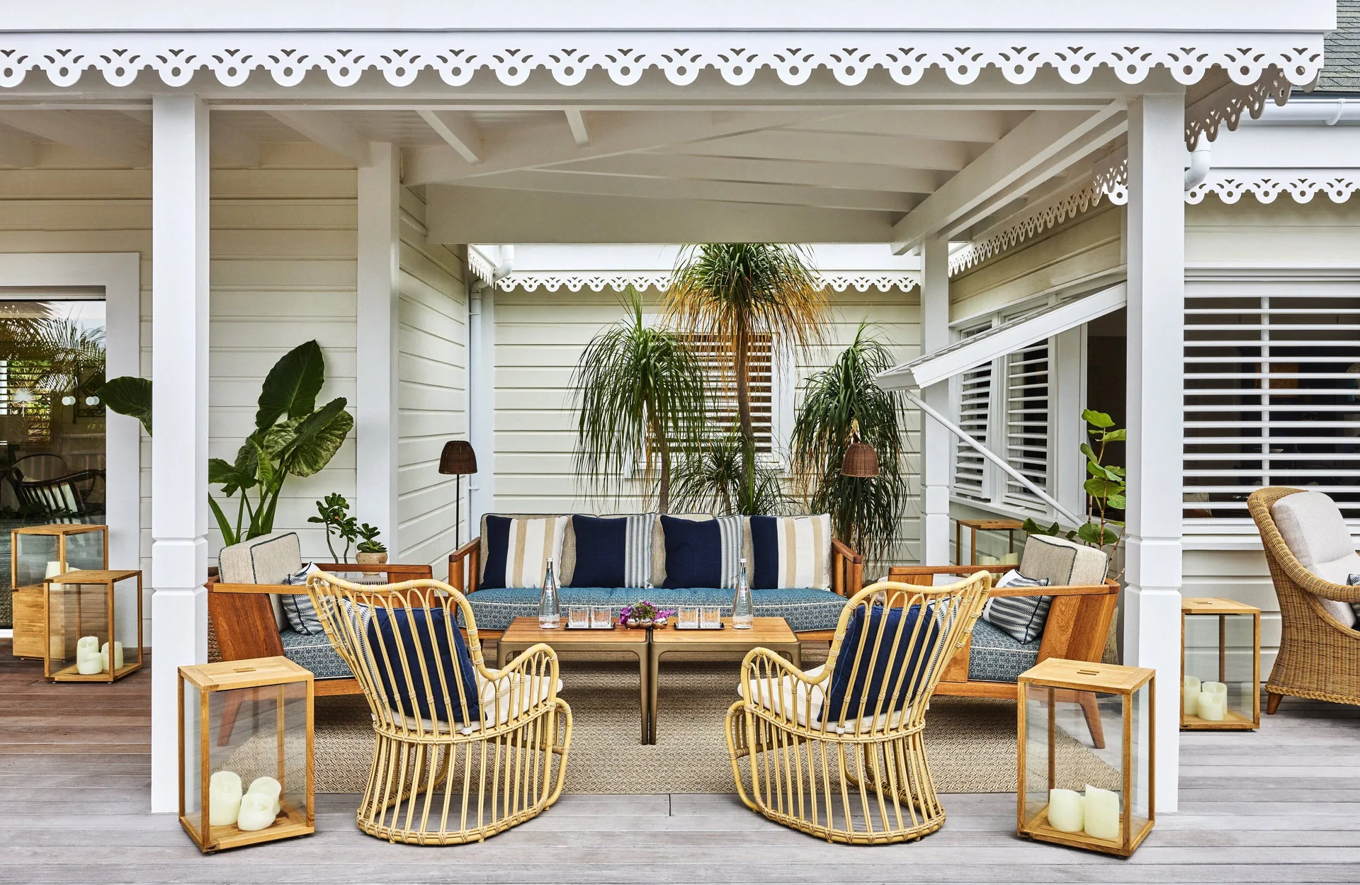 Covered outdoor lounge with wicker chairs and striped cushions at Rosewood Le Guanahani St Barth.