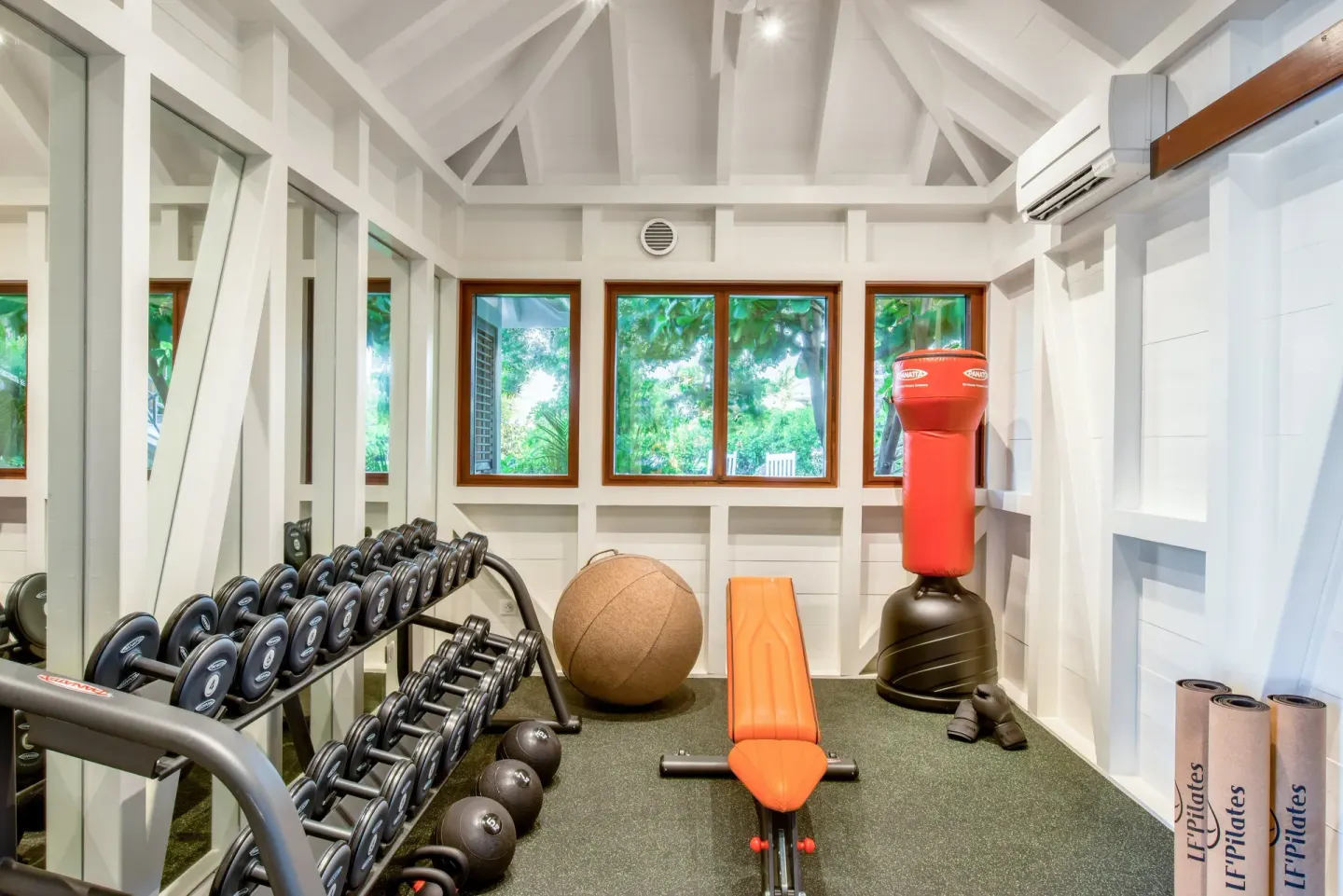 Fitness room with dumbbells, bench and punching bag at Rosewood Le Guanahani St Barth.