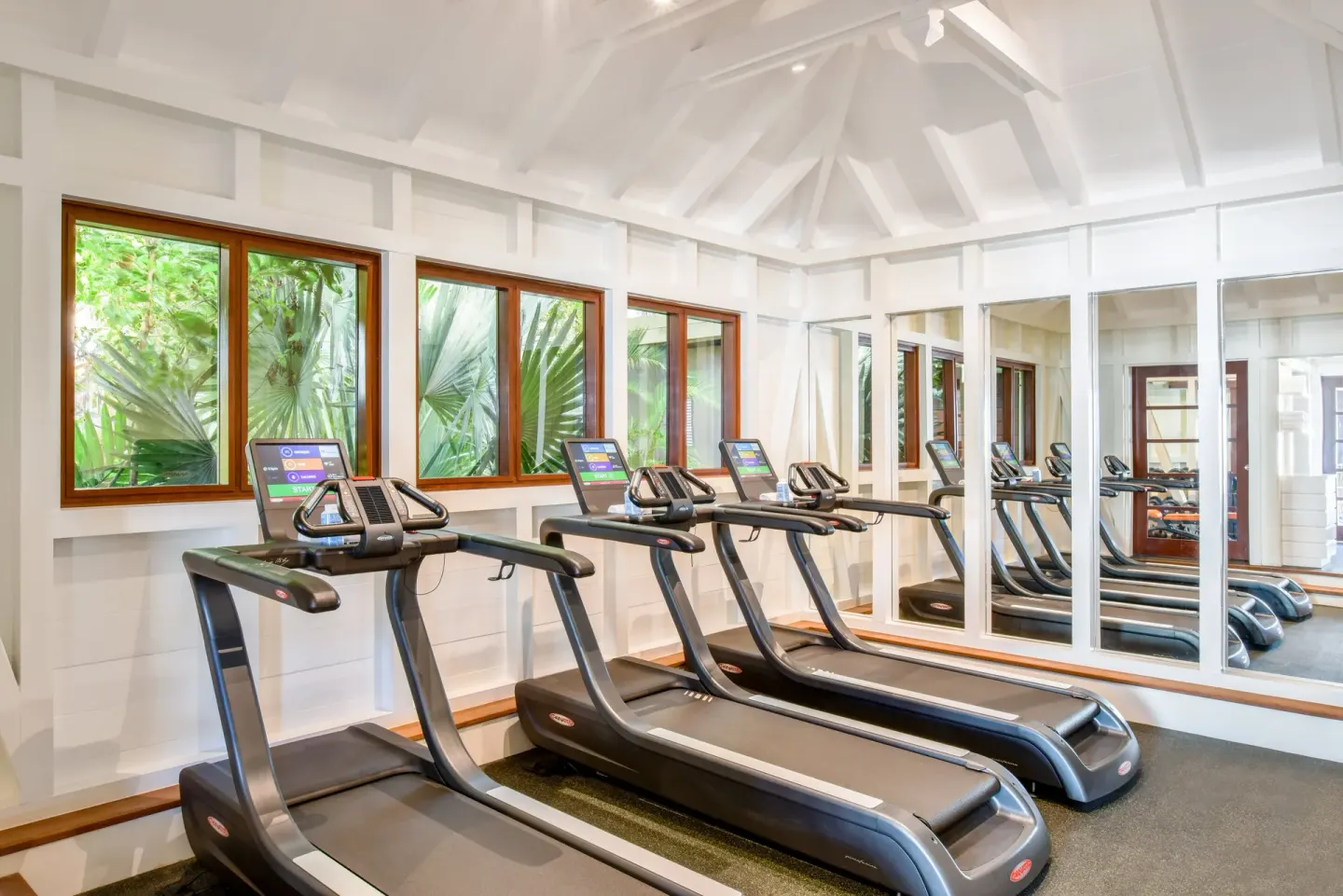 Treadmills line a bright fitness room at Rosewood Le Guanahani St Barth.