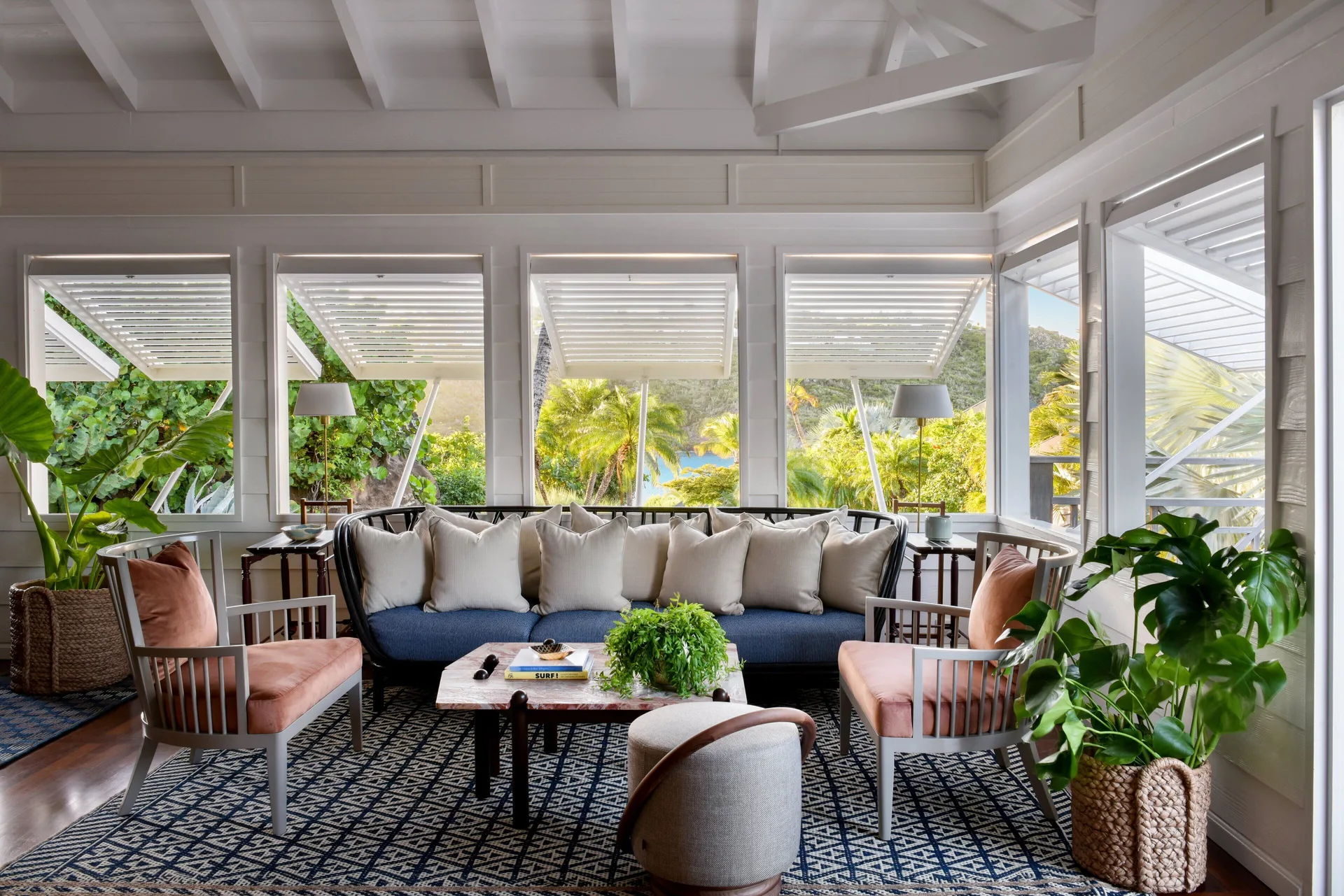 Bright lounge with sofa, armchairs, plants, and garden views at Rosewood Le Guanahani St Barth.
