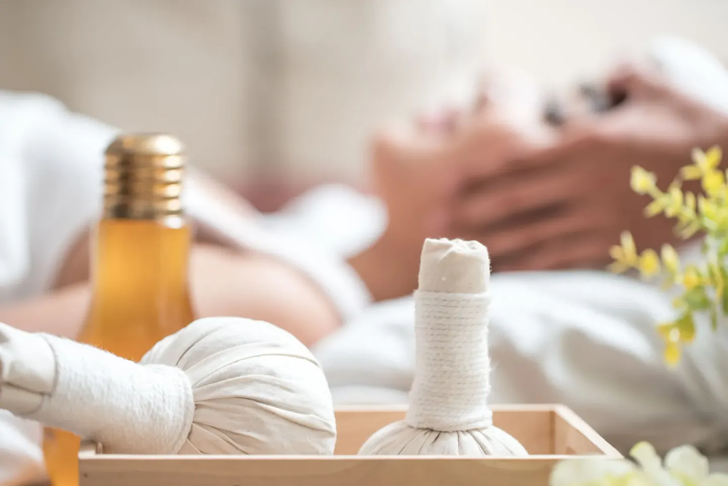Herbal compresses and oil sit beside a massage bed at Rosewood Le Guanahani St Barth.