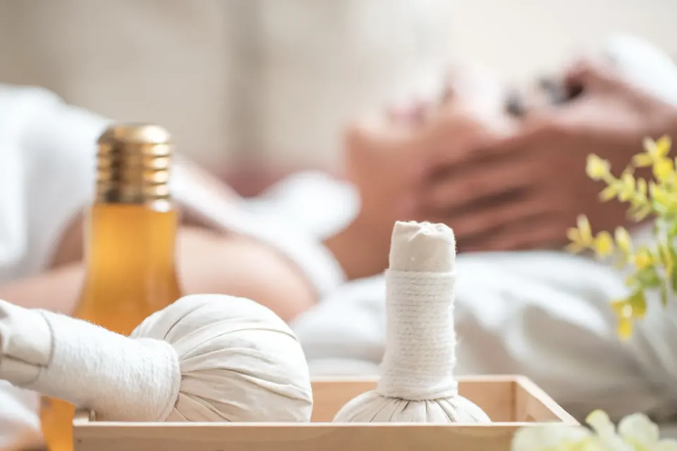 Herbal compresses and oil sit beside a massage bed at Rosewood Le Guanahani St Barth.