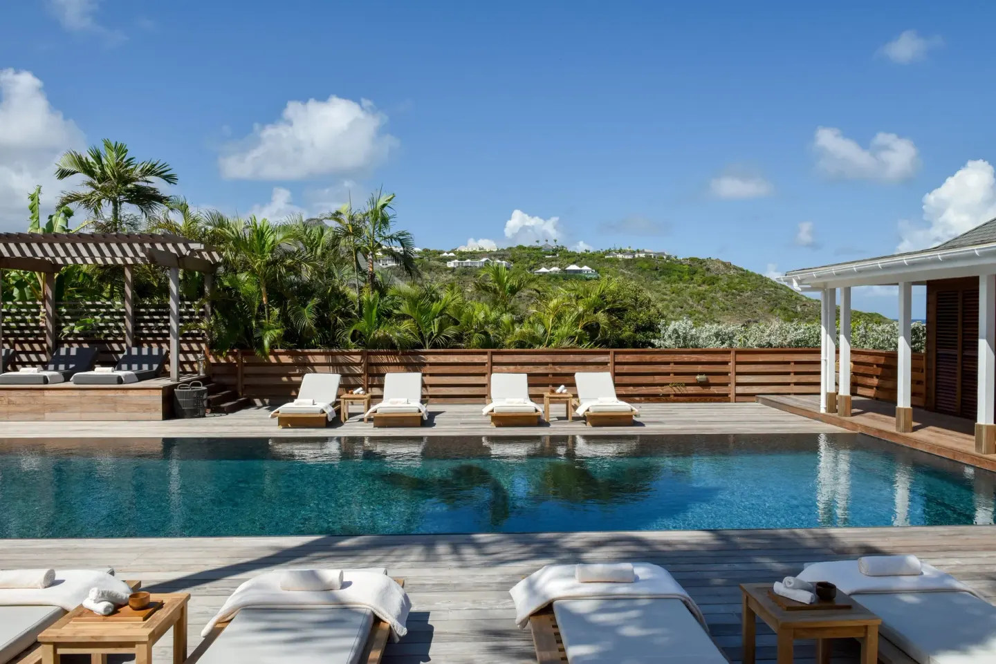 Pool deck with loungers and hillside views at Rosewood Le Guanahani St Barth.