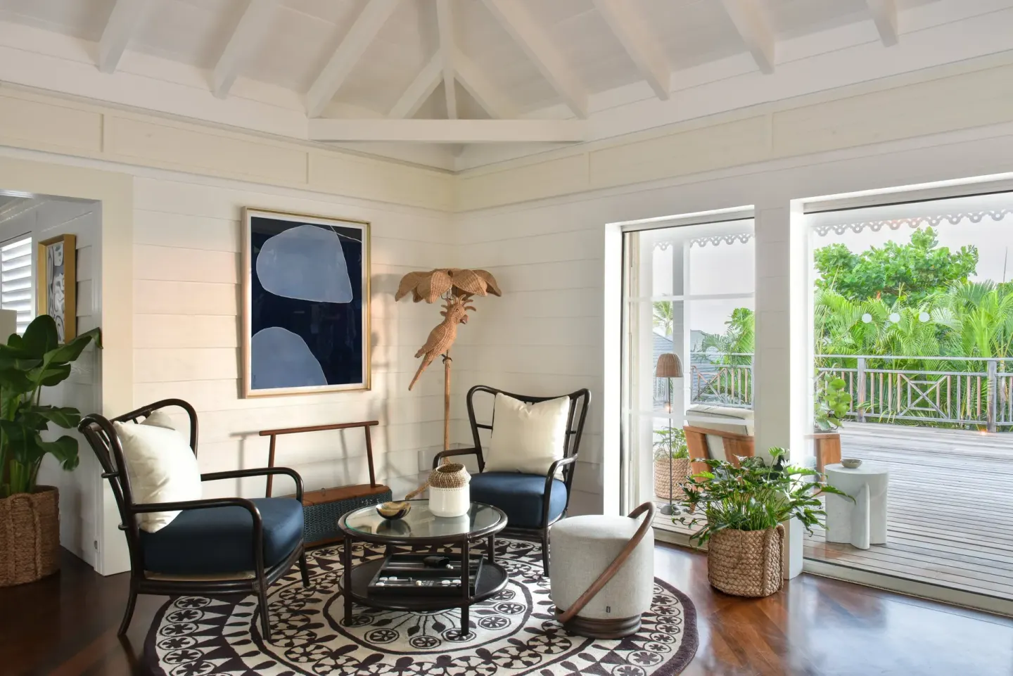 Sitting room with black chairs and open doors to a terrace at Rosewood Le Guanahani St Barth.