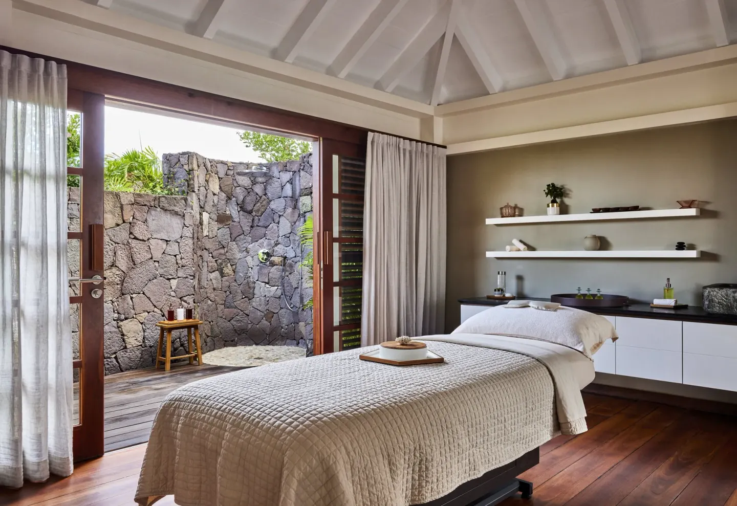 Spa treatment room with open-air stone shower at Rosewood Le Guanahani St Barth.