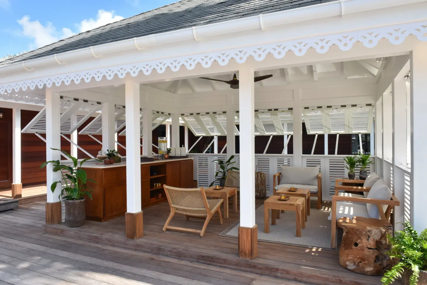 A shaded terrace lounge and bar area are shown at Rosewood Le Guanahani St Barth.