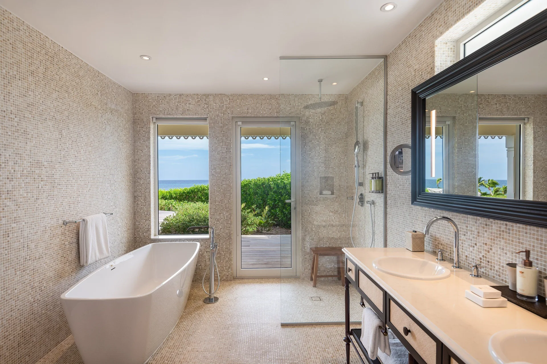 Bougainvillea Suite bathroom with soaking tub and shower at Rosewood Le Guanahani St Barth.