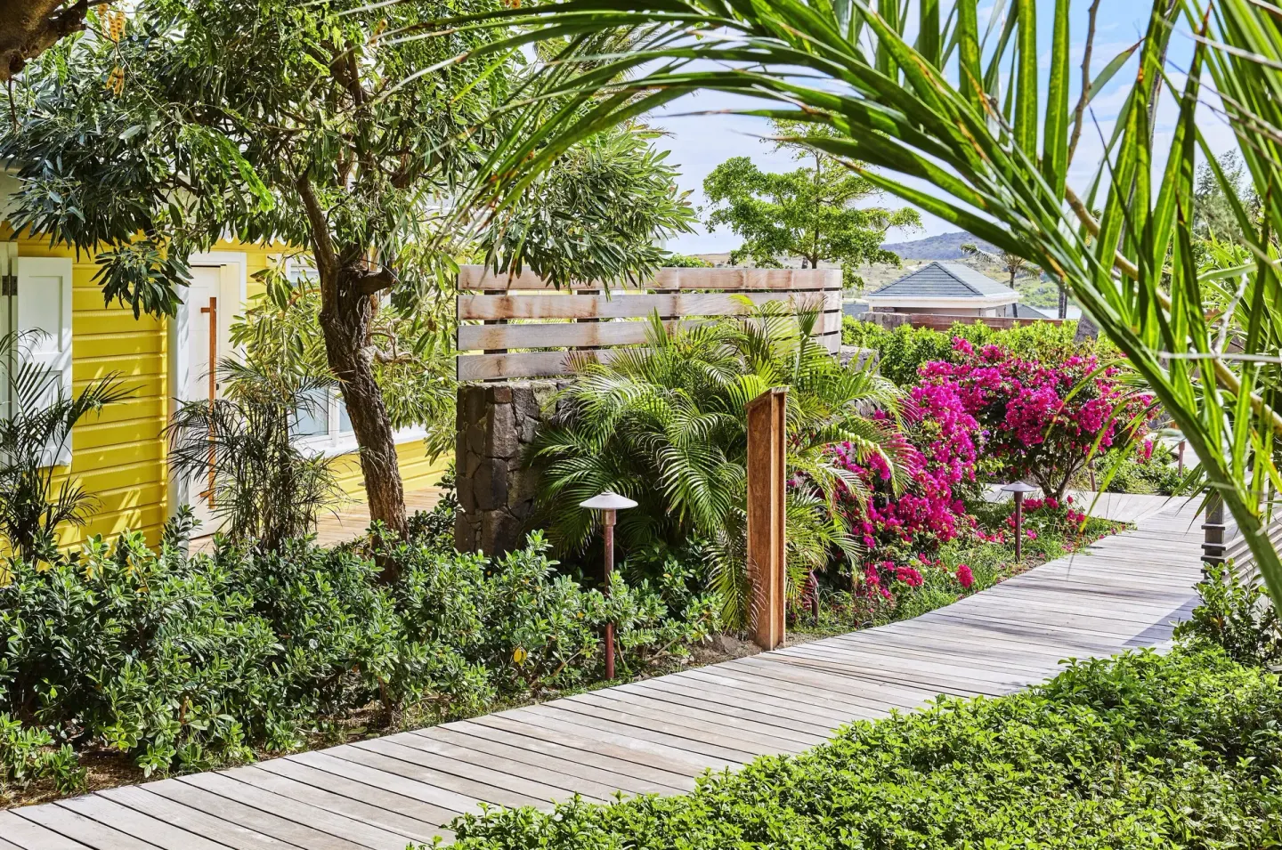 Bougainvillea Suite garden walkway and yellow cottage at Rosewood Le Guanahani St Barth.