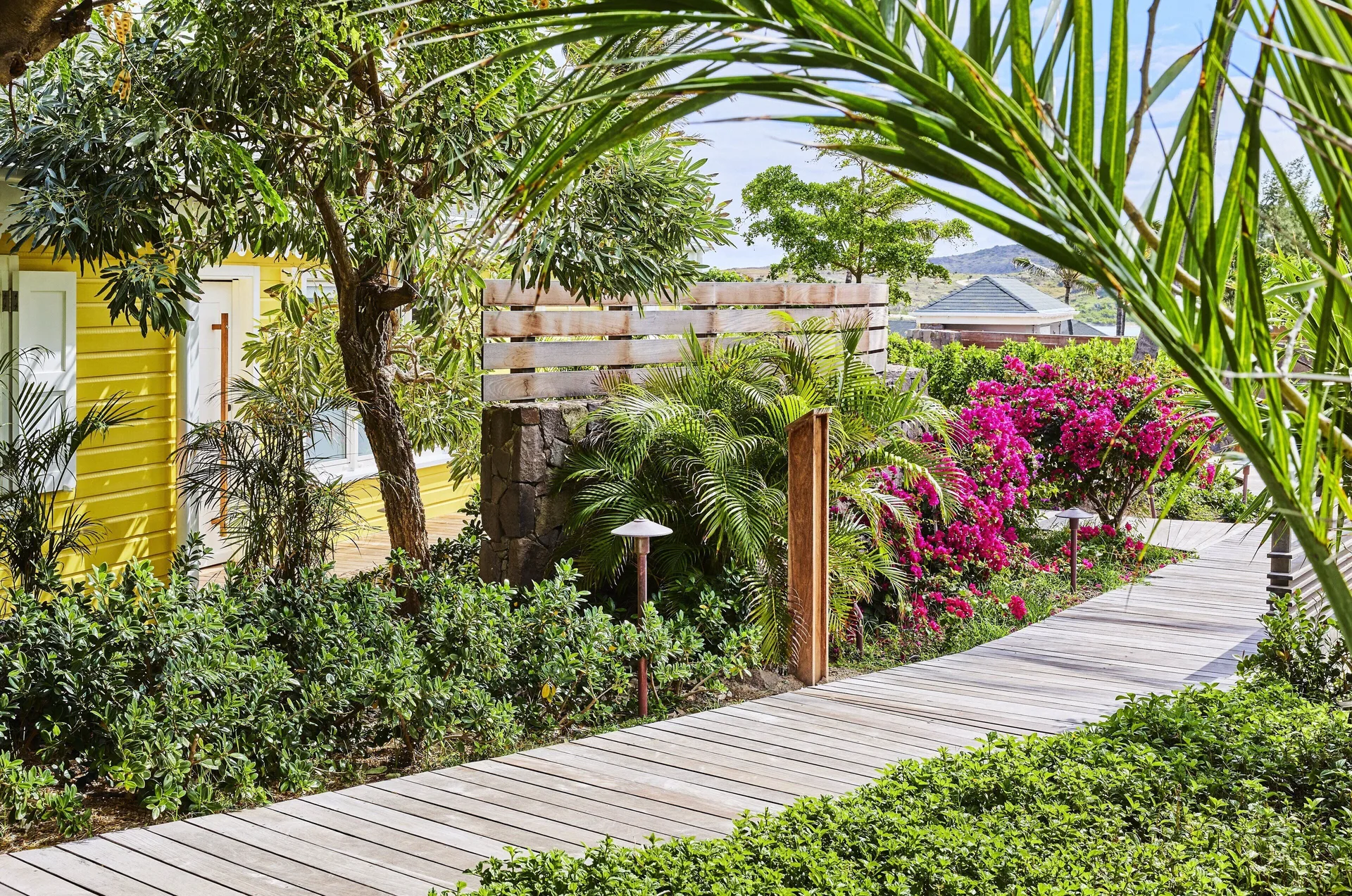 Bougainvillea Suite garden walkway and yellow cottage at Rosewood Le Guanahani St Barth.