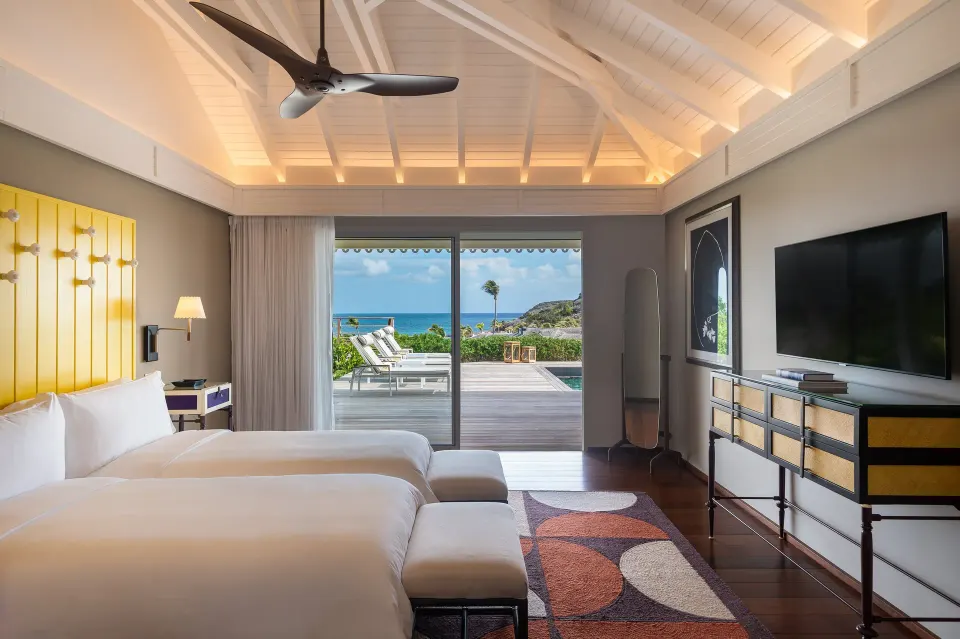 Bougainvillea Suite bedroom with twin beds and terrace at Rosewood Le Guanahani St Barth.