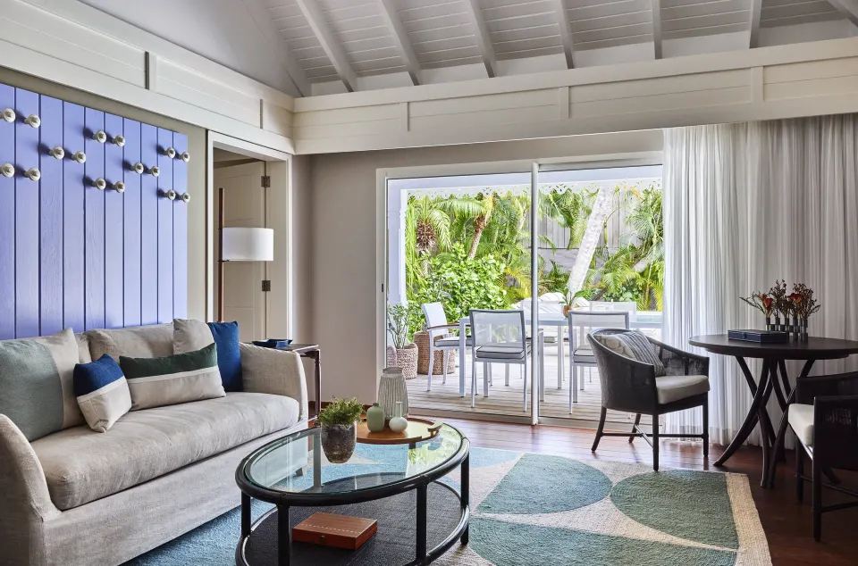 Hibiscus Suite living room with sofa and terrace doors at Rosewood Le Guanahani St Barth.