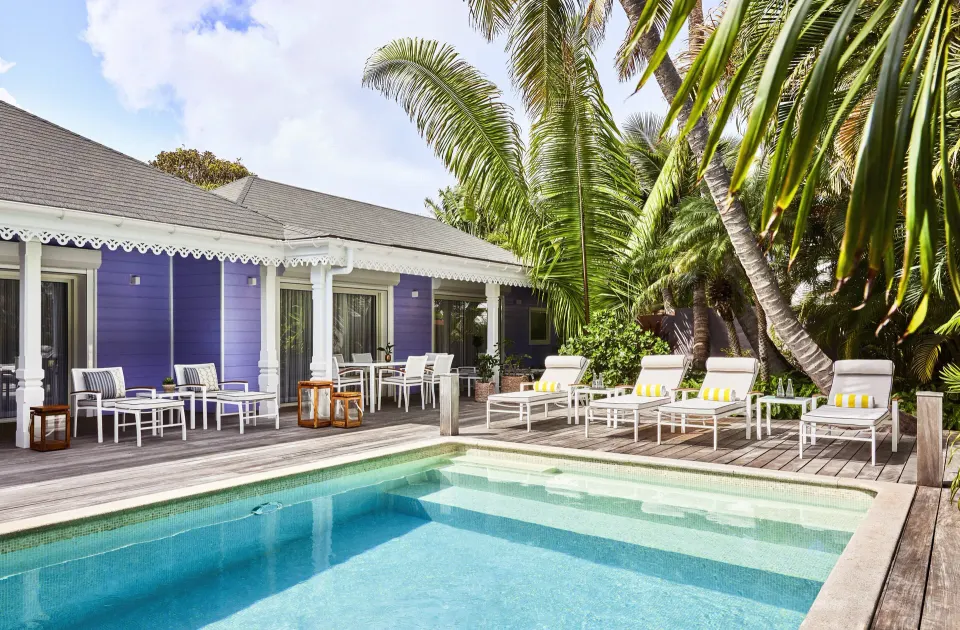 Hibiscus Suite pool terrace with purple cottage facade at Rosewood Le Guanahani St Barth.