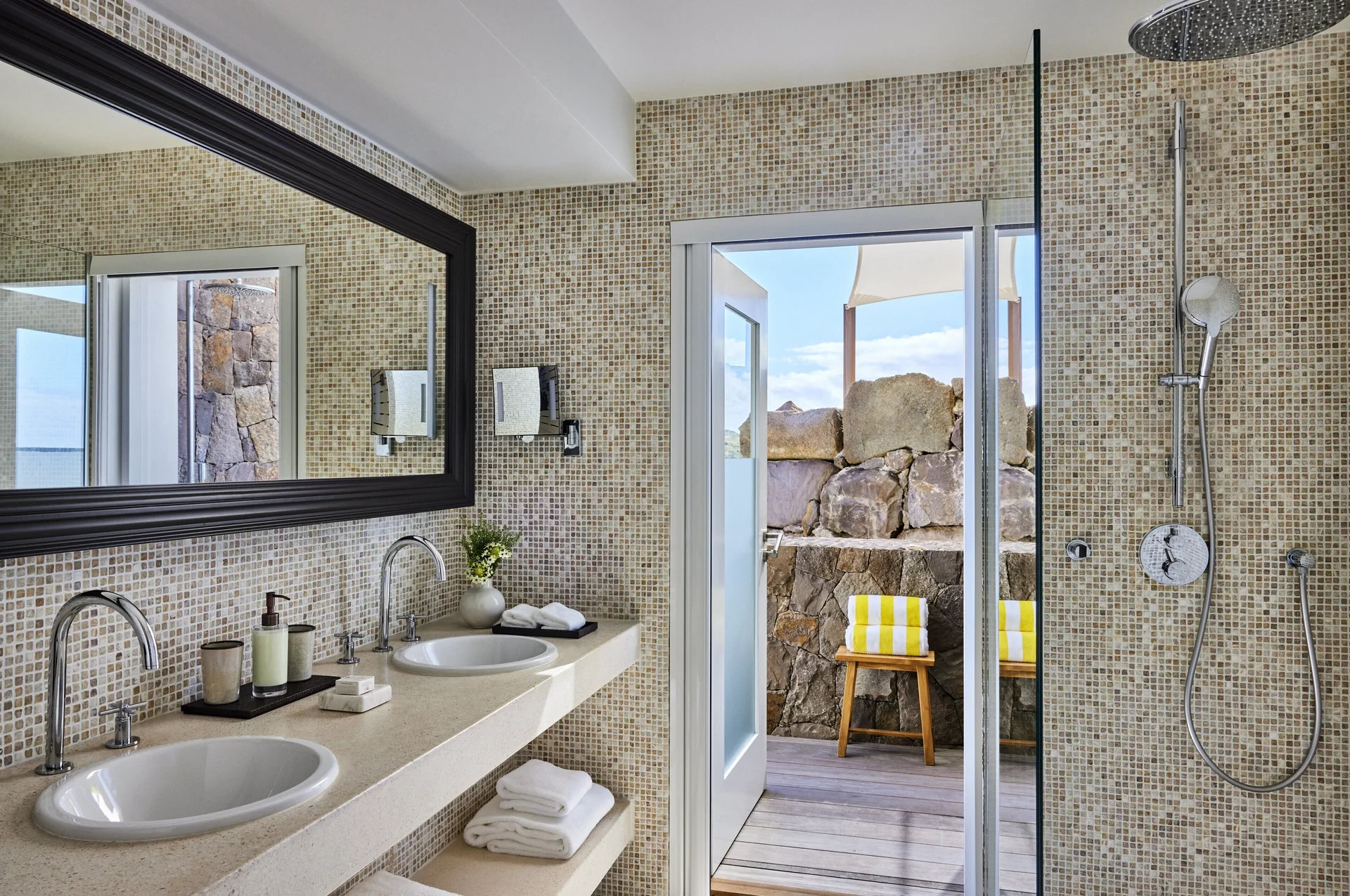 Lagoon Suite bathroom with double sinks and outdoor shower area at Rosewood Le Guanahani St Barth.
