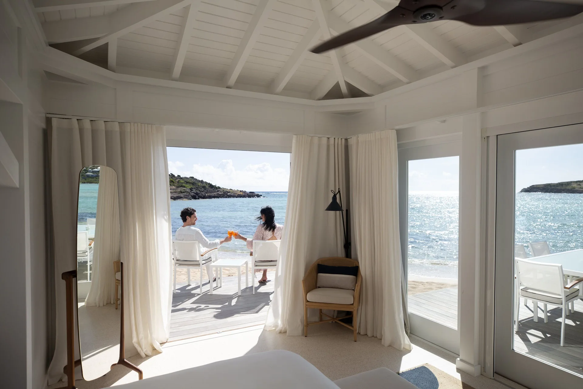 Lagoon Suite bedroom view to terrace seating and water at Rosewood Le Guanahani St Barth.
