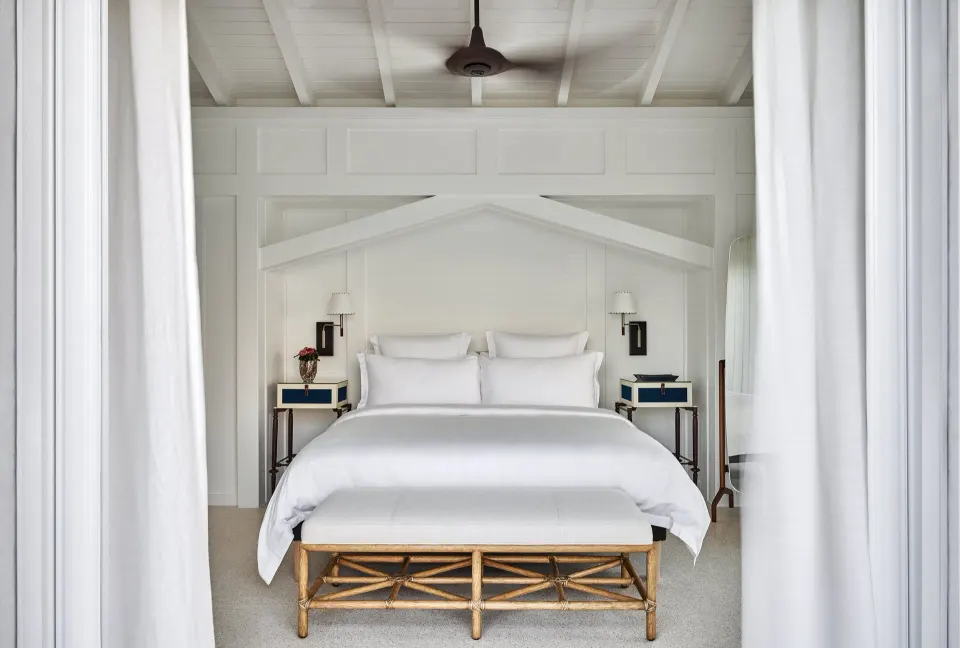 Lagoon Suite king bed framed by white curtains at Rosewood Le Guanahani St Barth.