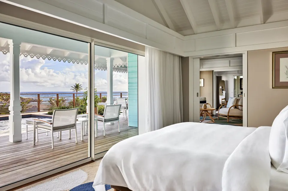 Marechal Suite bed beside sliding doors to the terrace at Rosewood Le Guanahani St Barth.