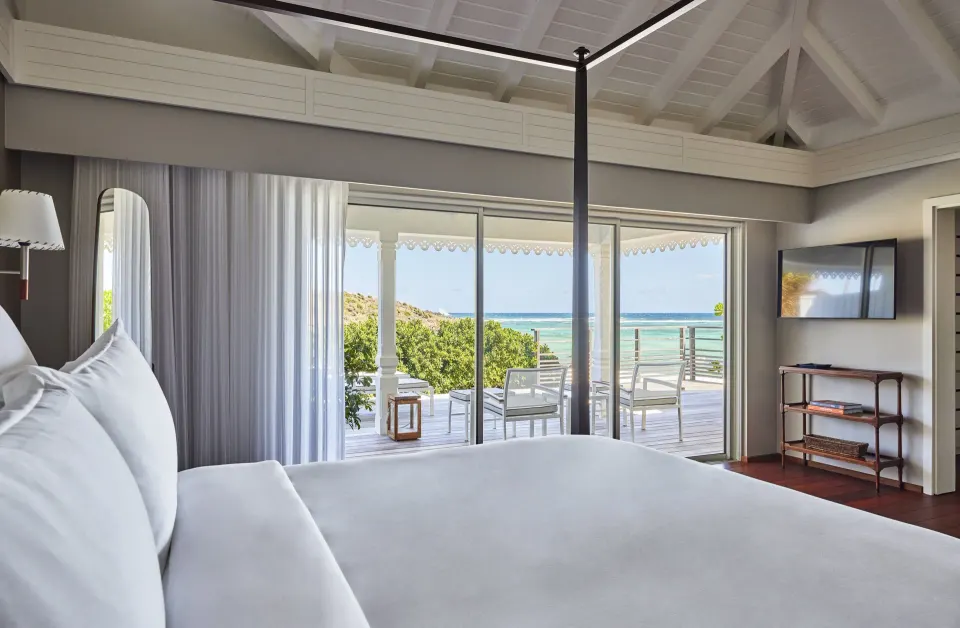 Ocean Cove Junior Suite king bed and terrace view at Rosewood Le Guanahani St Barth.