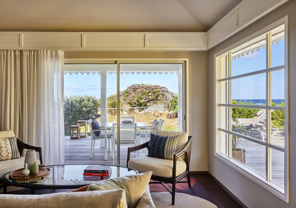Pelican Suite living room opening to a terrace and sea view at Rosewood Le Guanahani St Barth.