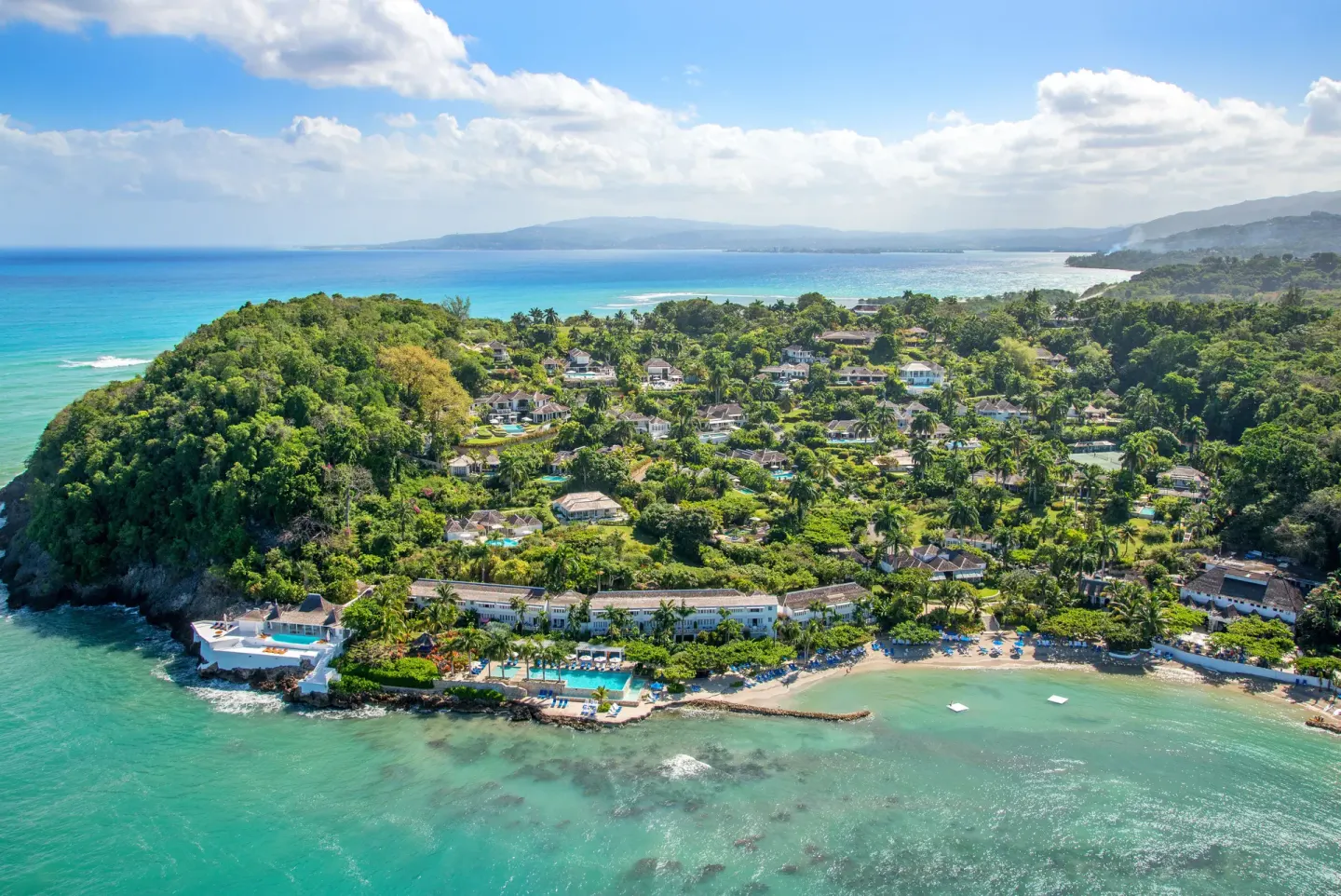 Aerial view of the beachfront resort and turquoise sea at Round Hill Hotel And Villas.