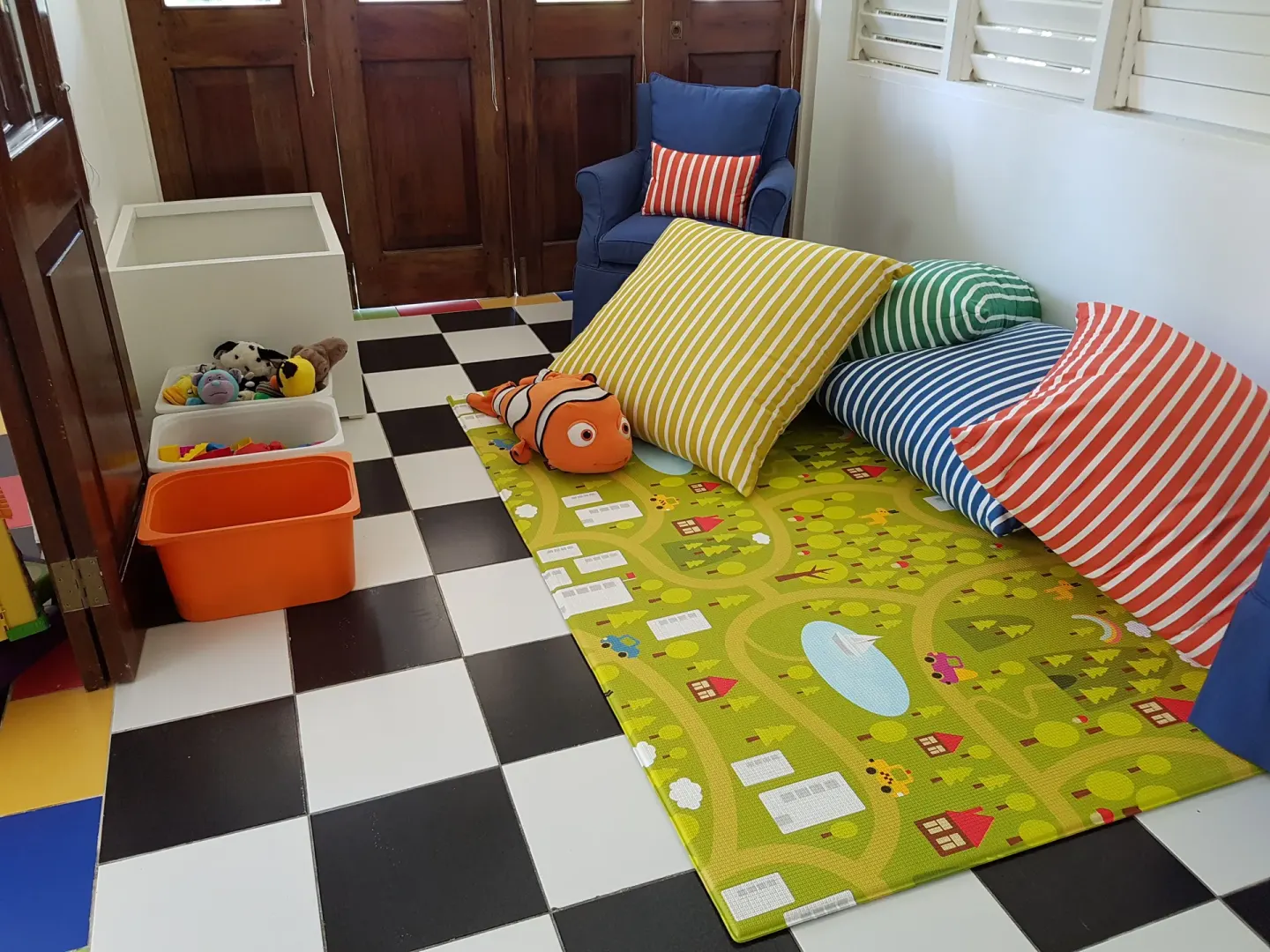 Children's play area with floor mat, striped pillows and toy bins at Round Hill Hotel And Villas.