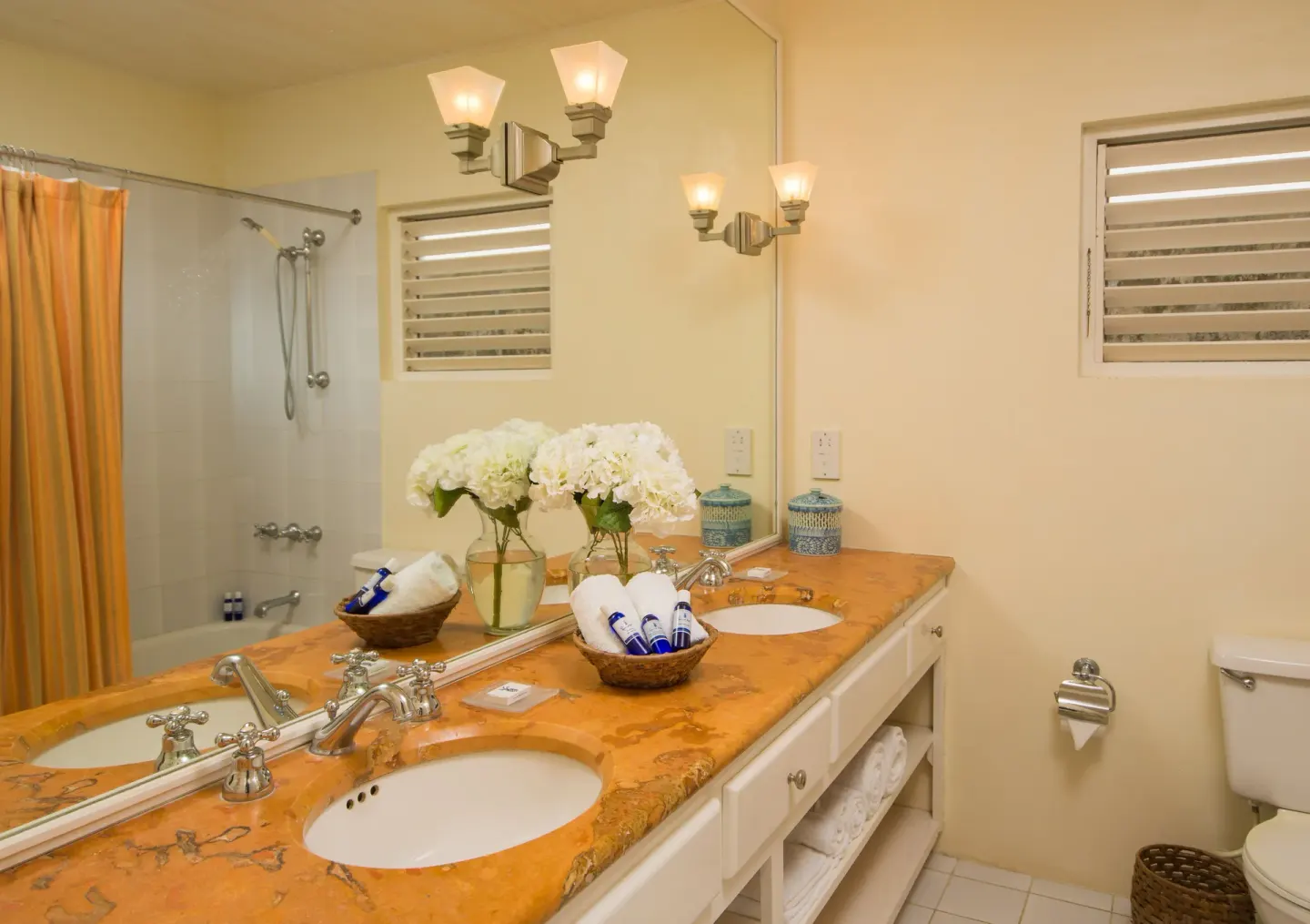 Guest bathroom with double vanity and tub-shower at Round Hill Hotel And Villas.