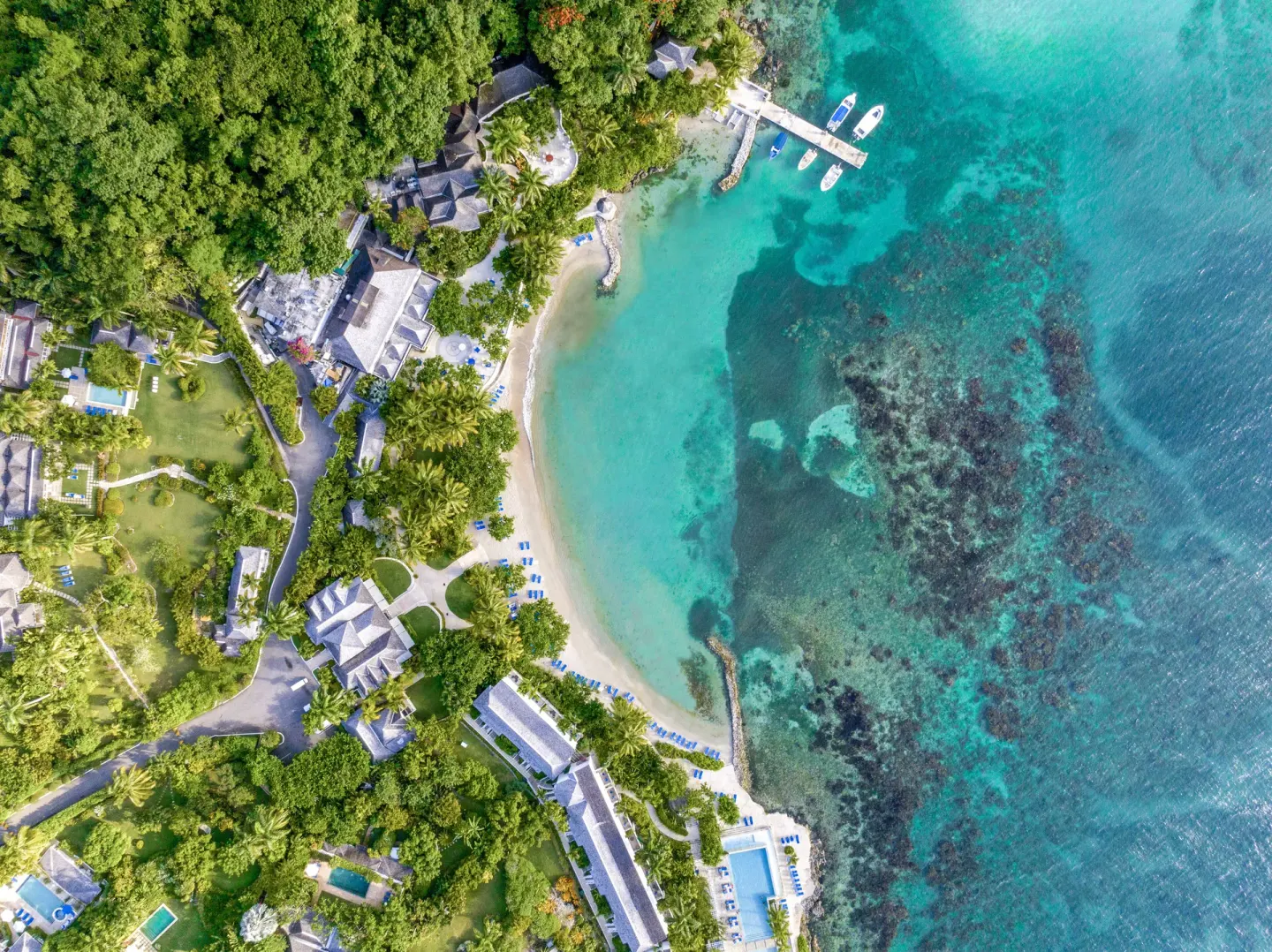 Overhead aerial view of the beach, pier, and reef at Round Hill Hotel And Villas.