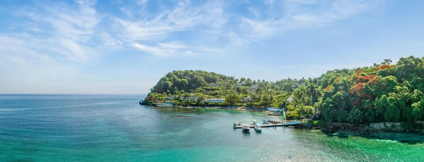 A panoramic coastline view shows turquoise water and wooded headlands at Round Hill Hotel And Villas.