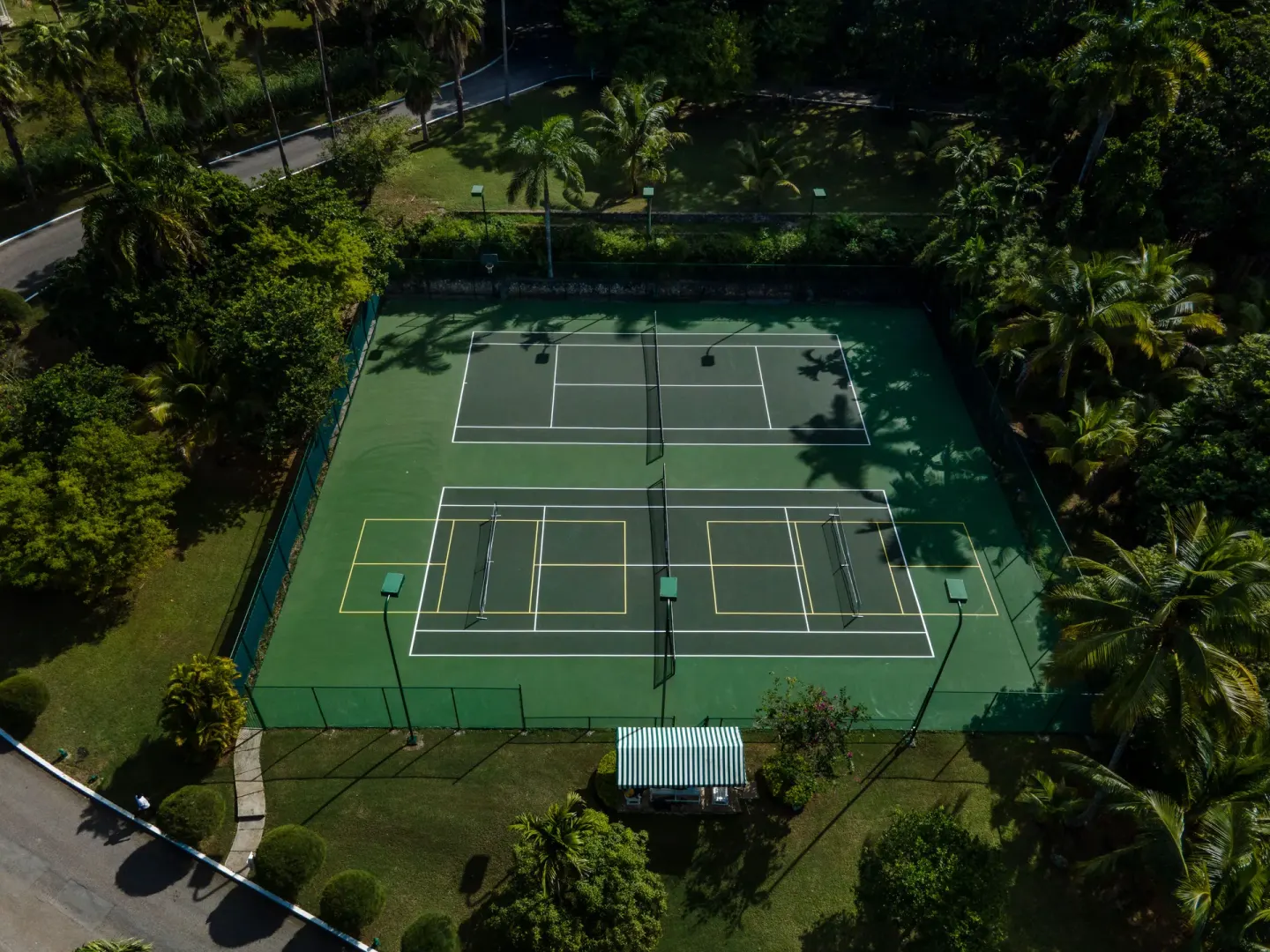 Aerial view of tennis courts surrounded by palms at Round Hill Hotel And Villas.