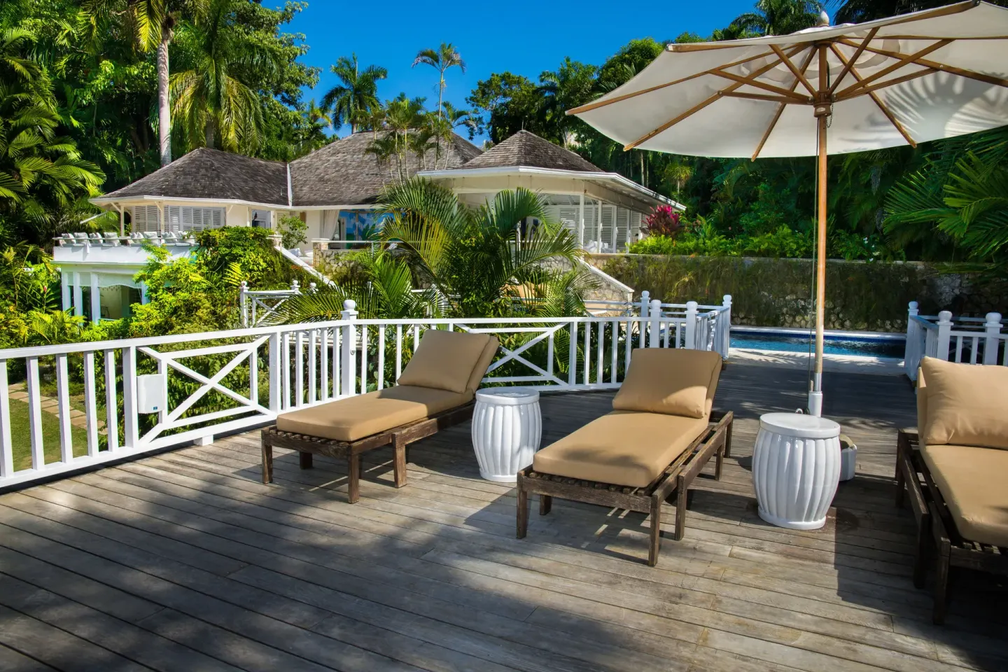 Sun loungers and umbrella on a villa deck at Round Hill Hotel And Villas.