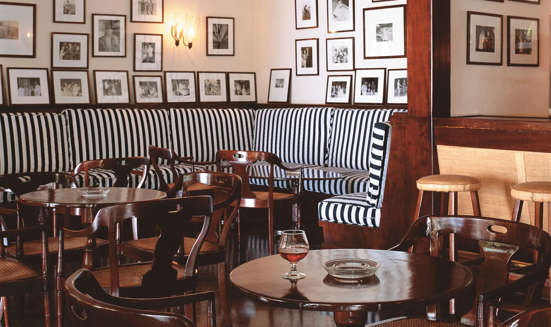 Classic bar lounge seating with framed photos at Round Hill Hotel And Villas.
