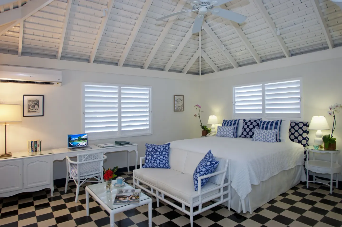 King bedroom with desk and lounge seating at Round Hill Hotel And Villas.